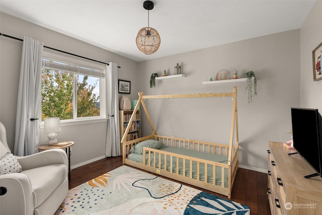 bedroom with dark wood-type flooring and a nursery area