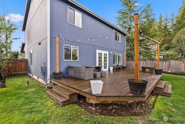 rear view of house with a lawn, french doors, and a deck