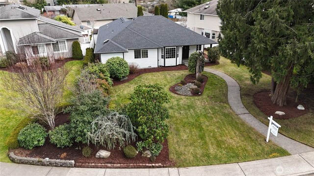 view of front facade with a residential view, roof with shingles, and a front lawn