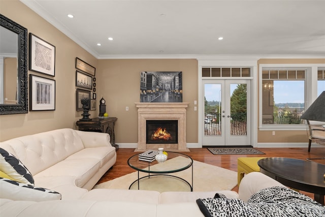 living room with french doors, ornamental molding, a high end fireplace, and hardwood / wood-style floors