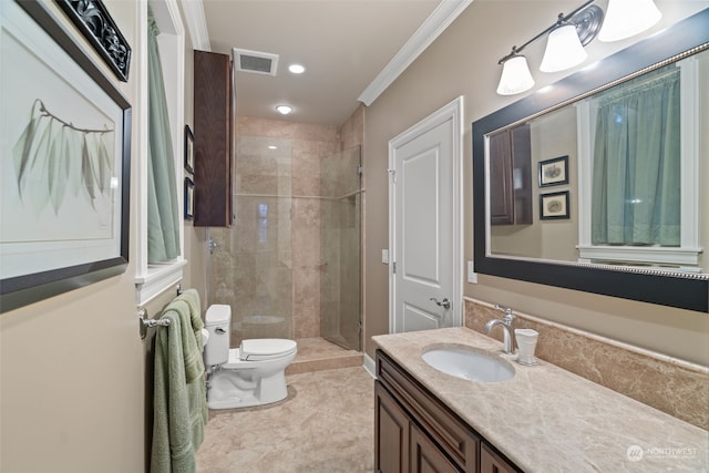 bathroom with tile patterned flooring, toilet, a tile shower, ornamental molding, and vanity