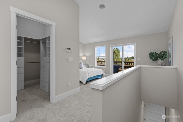 unfurnished bedroom featuring a walk in closet, light colored carpet, a closet, and access to outside