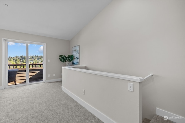 corridor with lofted ceiling and carpet floors