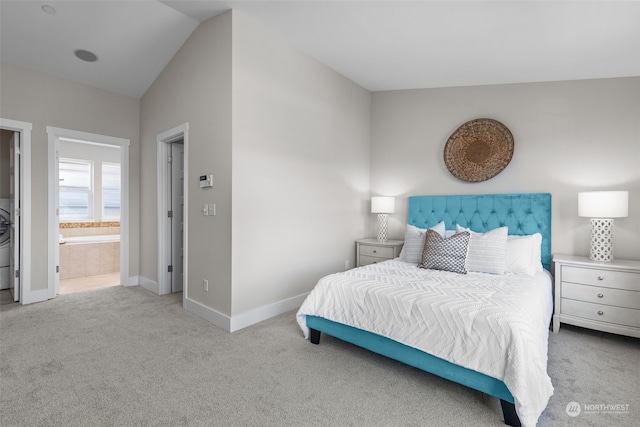 carpeted bedroom with lofted ceiling and ensuite bath