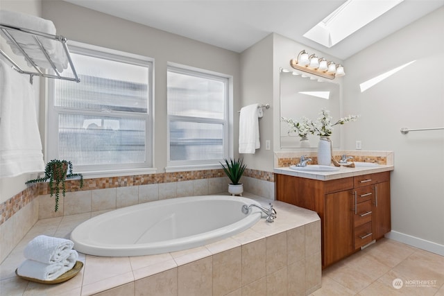 bathroom featuring a relaxing tiled tub, vanity, a skylight, and tile patterned flooring