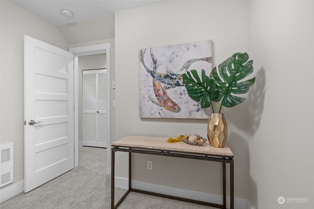 interior space featuring vaulted ceiling and light carpet