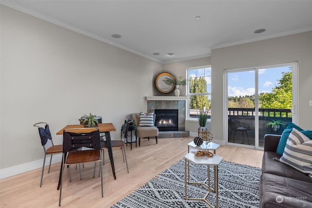 living room featuring crown molding, a fireplace, and light wood-type flooring