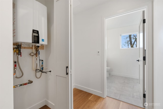 bathroom with toilet, wood-type flooring, and tankless water heater