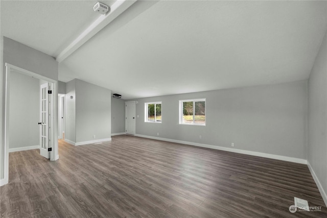 unfurnished living room featuring dark wood-type flooring and beam ceiling