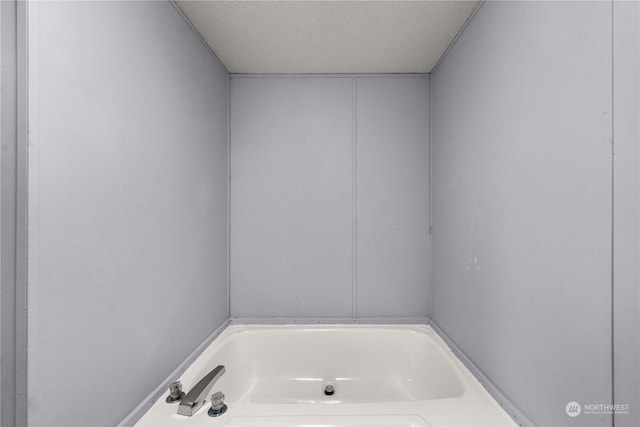 bathroom featuring a bathing tub and a textured ceiling