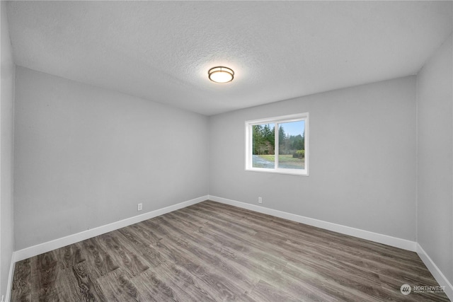 unfurnished room with a textured ceiling and hardwood / wood-style flooring