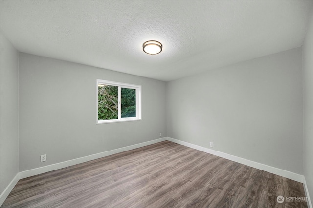 spare room featuring a textured ceiling and hardwood / wood-style floors