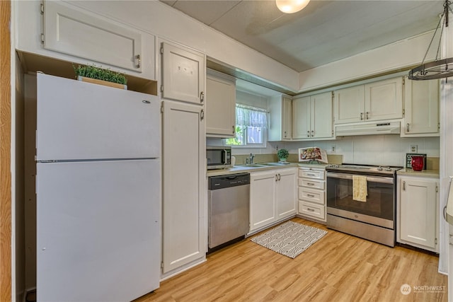 kitchen featuring pendant lighting, stainless steel appliances, light hardwood / wood-style floors, and white cabinets