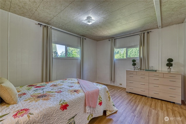 bedroom with multiple windows and light hardwood / wood-style floors