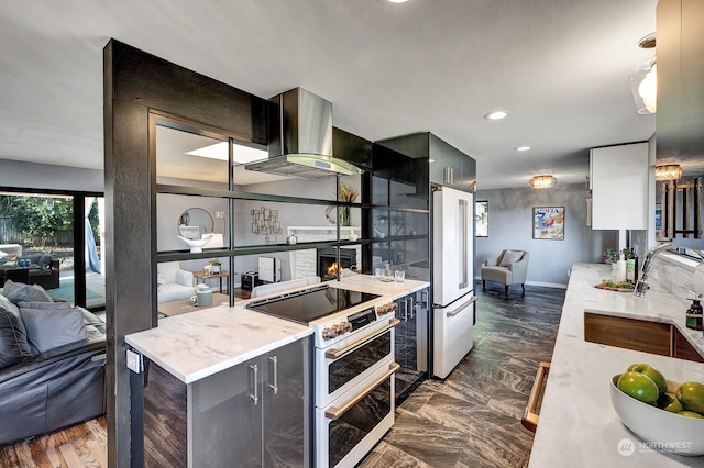 kitchen featuring a fireplace, sink, island exhaust hood, and high end appliances