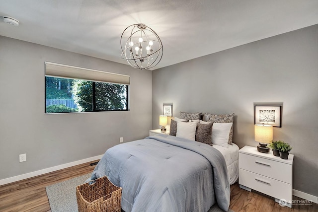 bedroom with a chandelier and hardwood / wood-style floors