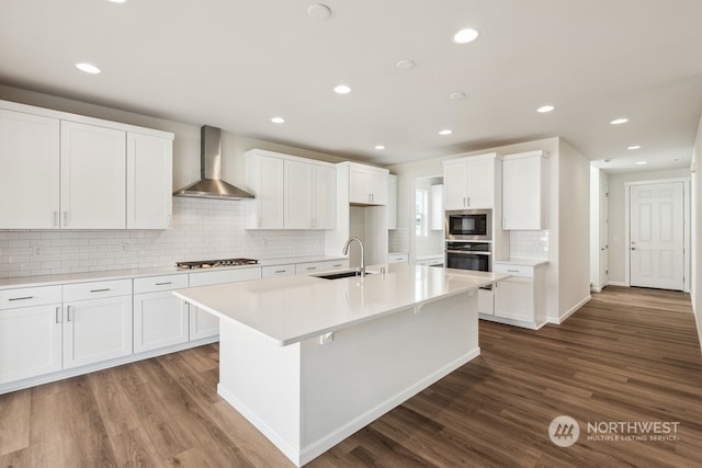 kitchen featuring white cabinets, sink, wall chimney range hood, and stainless steel appliances