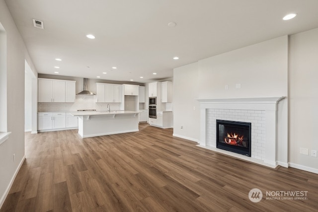 unfurnished living room featuring a brick fireplace and hardwood / wood-style floors