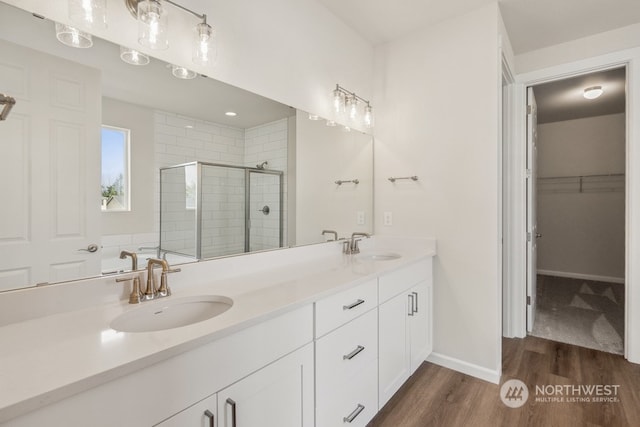 bathroom with hardwood / wood-style flooring, a shower with door, and vanity