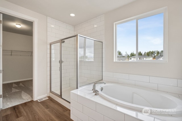 bathroom featuring hardwood / wood-style floors, independent shower and bath, and a healthy amount of sunlight