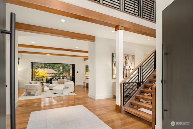 entryway with light wood-type flooring and beamed ceiling