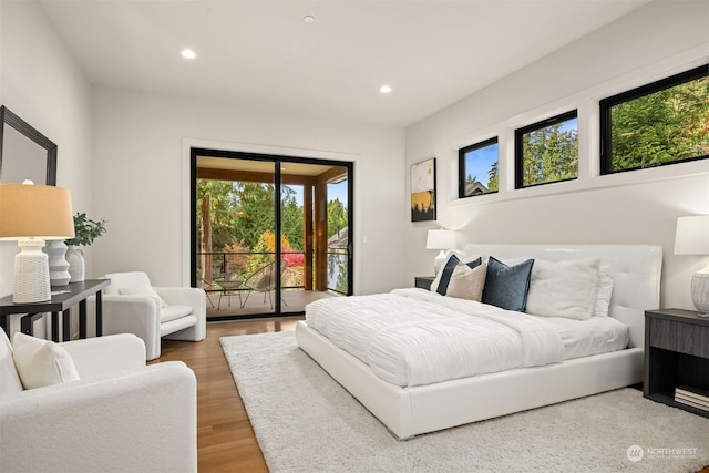 bedroom with access to exterior and wood-type flooring