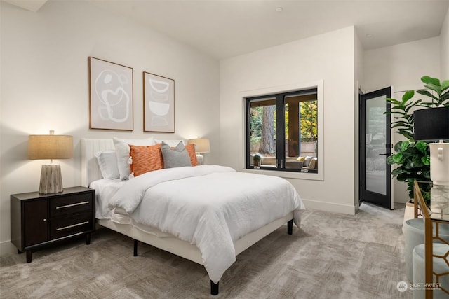 bedroom with light colored carpet and access to outside