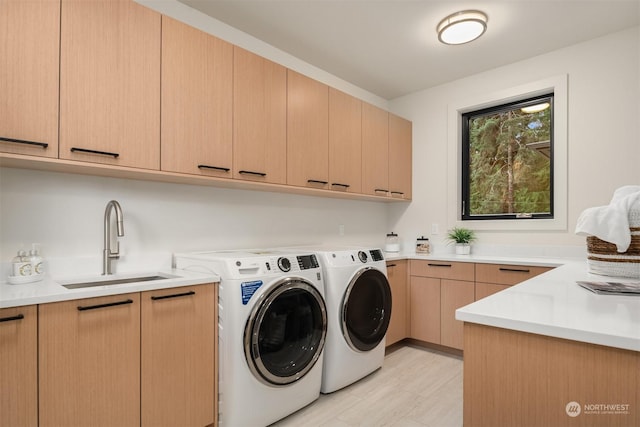 laundry area featuring sink, cabinets, and washing machine and dryer