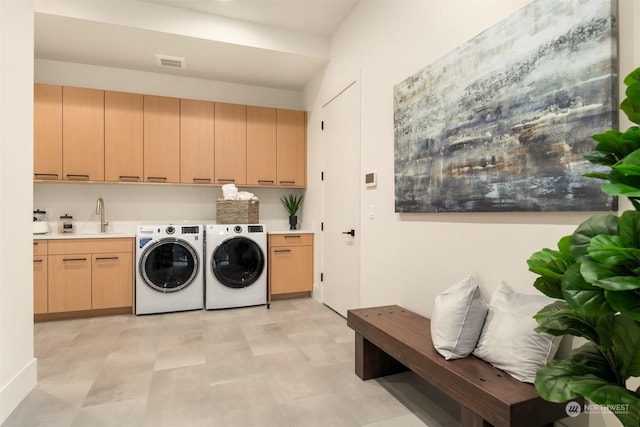 laundry area featuring sink, cabinets, and washer and dryer