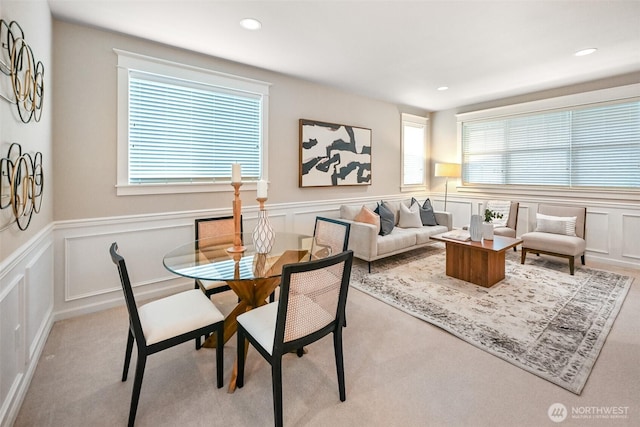 dining room with wainscoting, a decorative wall, and recessed lighting