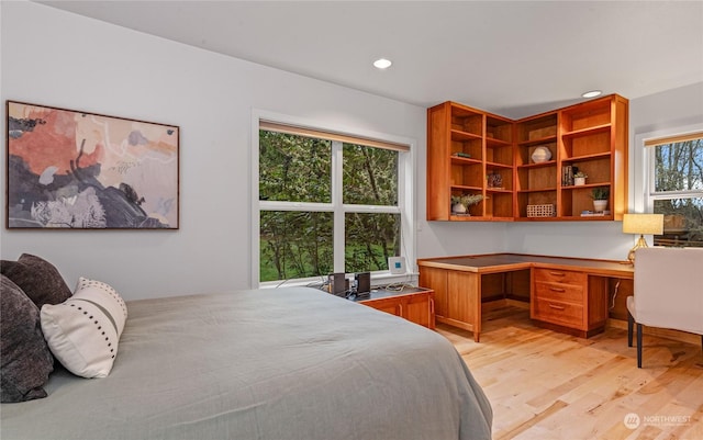 bedroom featuring built in desk and light wood-type flooring