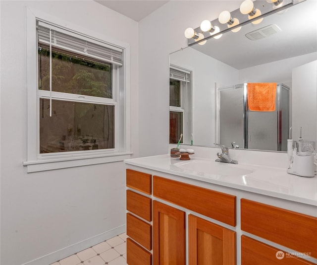 bathroom featuring a shower with door and vanity