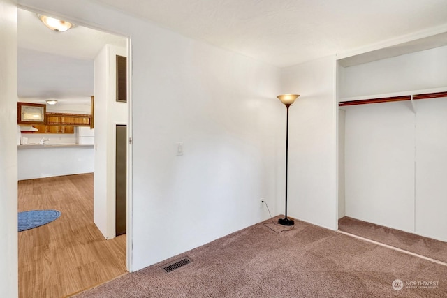 unfurnished bedroom featuring a closet and light carpet