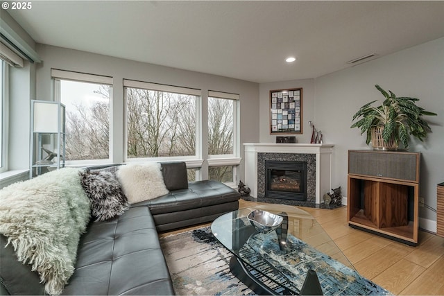 living room featuring wood-type flooring and a high end fireplace