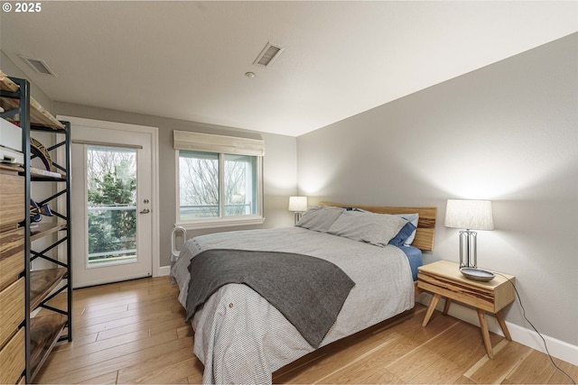 bedroom featuring access to exterior and light hardwood / wood-style flooring