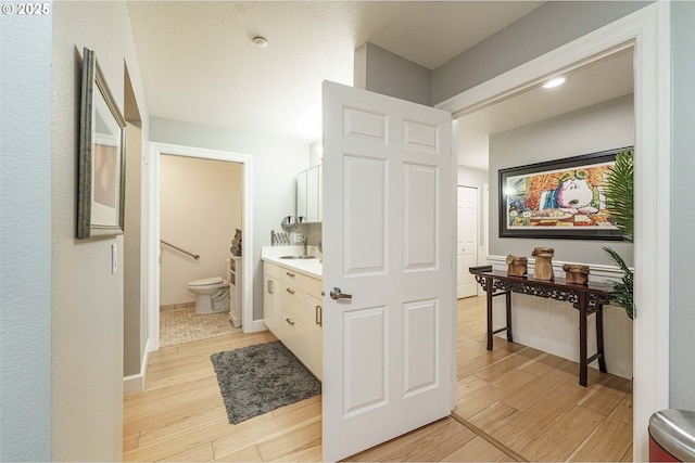 bathroom with toilet, hardwood / wood-style floors, and vanity