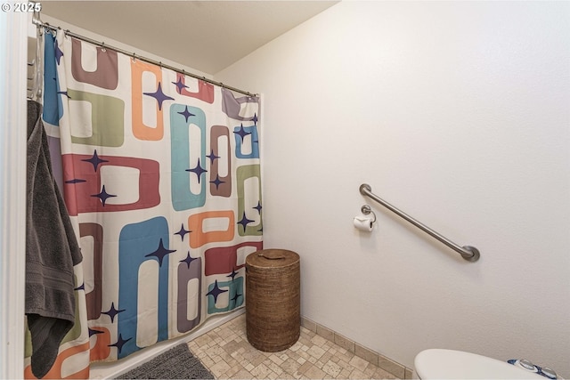 bathroom with curtained shower and toilet