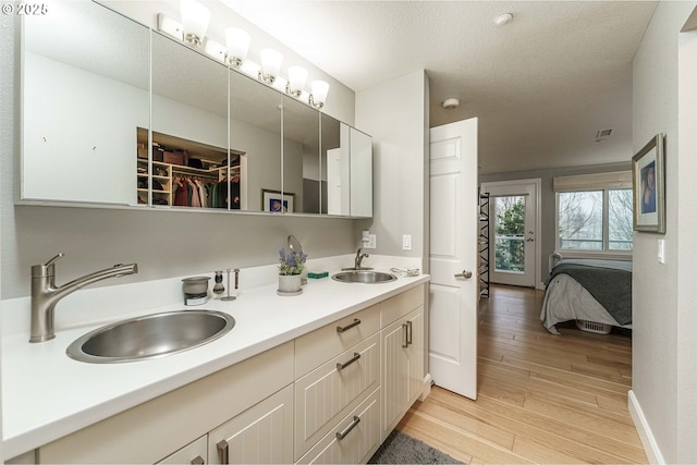 bathroom featuring a textured ceiling, hardwood / wood-style flooring, and vanity