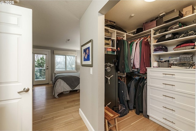 walk in closet with light hardwood / wood-style flooring