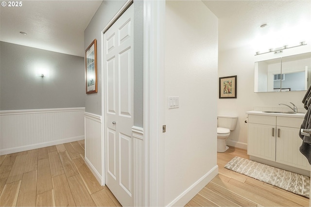 bathroom featuring toilet, hardwood / wood-style flooring, and vanity