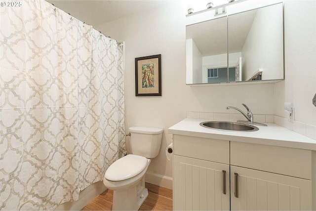 bathroom with wood-type flooring, toilet, and vanity