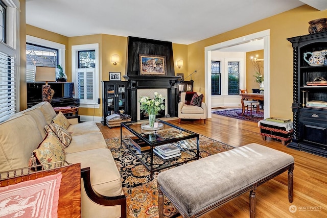 living room with a fireplace, hardwood / wood-style flooring, and a chandelier