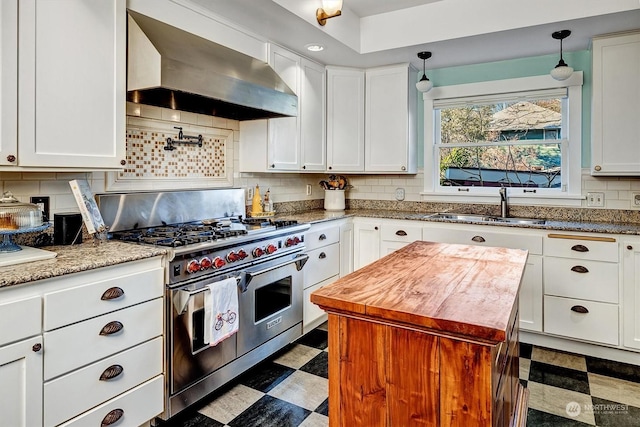 kitchen featuring sink, double oven range, exhaust hood, and white cabinetry