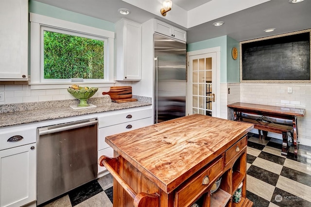 kitchen featuring white cabinets, light stone counters, and appliances with stainless steel finishes