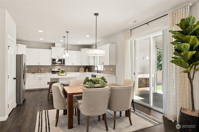 dining space with dark hardwood / wood-style floors and sink