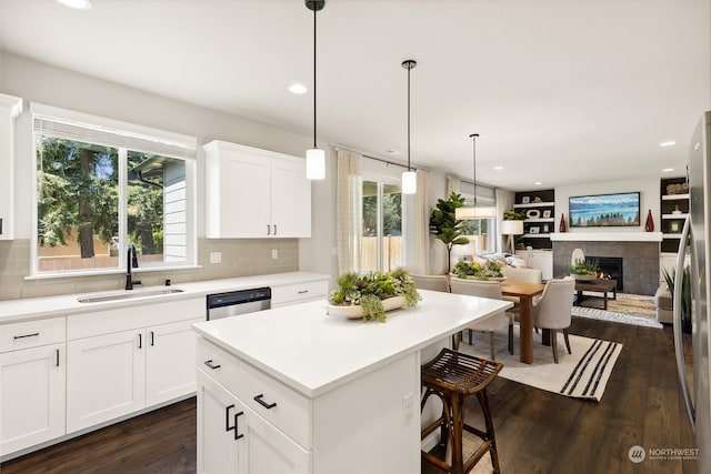 kitchen featuring sink, white cabinetry, appliances with stainless steel finishes, a kitchen breakfast bar, and a kitchen island