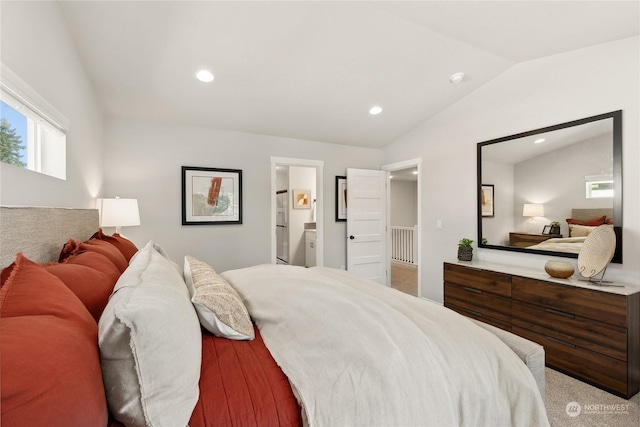 bedroom featuring lofted ceiling and ensuite bath