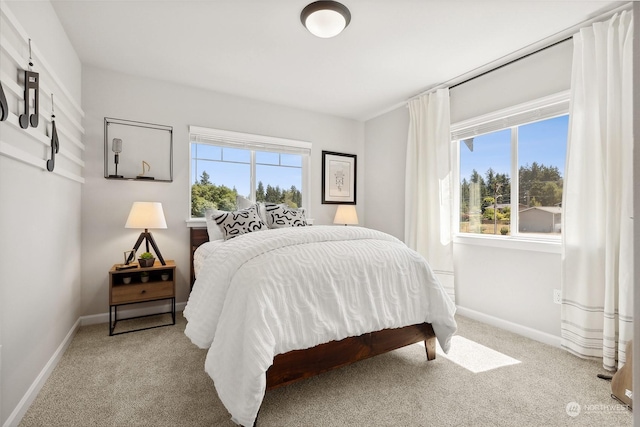 bedroom featuring light colored carpet and multiple windows