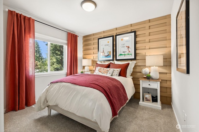 bedroom featuring light colored carpet and wood walls