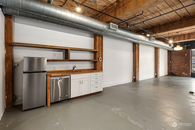 basement featuring stainless steel fridge and sink